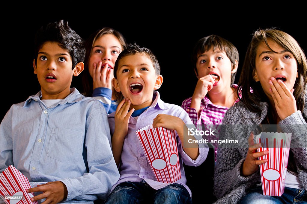 Kids at the movies Group of kids watching a film at the movies Adult Stock Photo
