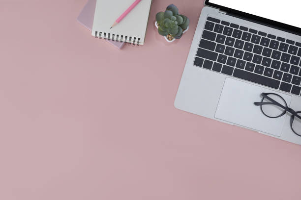 istock Laptop computer, glasses and notebook on pink background. Feminine workplace, Top view with copy space. 1395087821