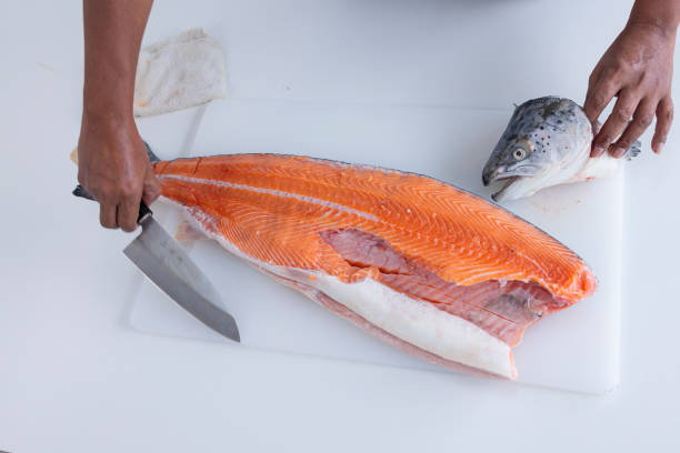 istock Human hand slicing salmon,Slicing Salmon 1395087964
