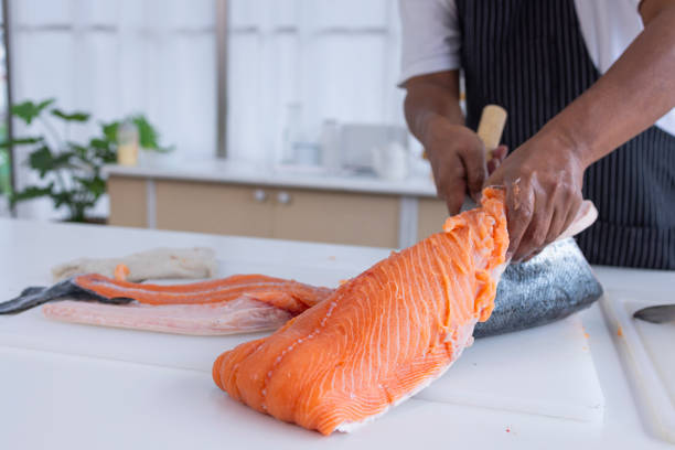 istock Human hand slicing salmon,Slicing Salmon 1395087979