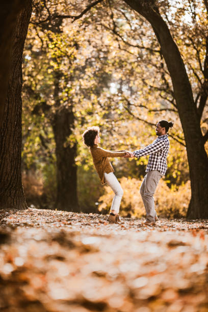 istock Carefree black couple having fun while spinning in autumn day. 1395088707