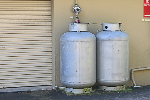Two large gas cylinders next to a wall