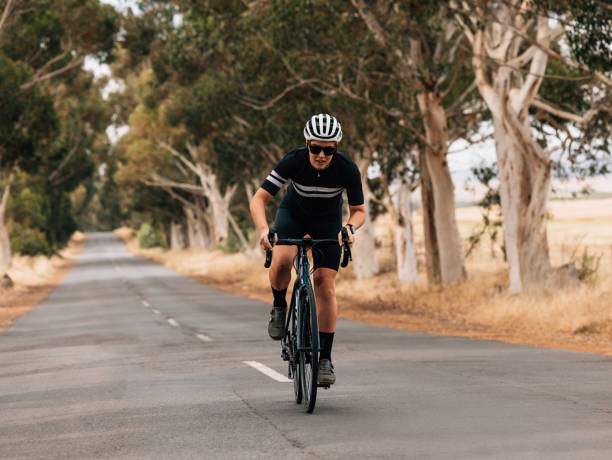 istock Professional female cyclist doing intense training on empty countryside road 1395093376