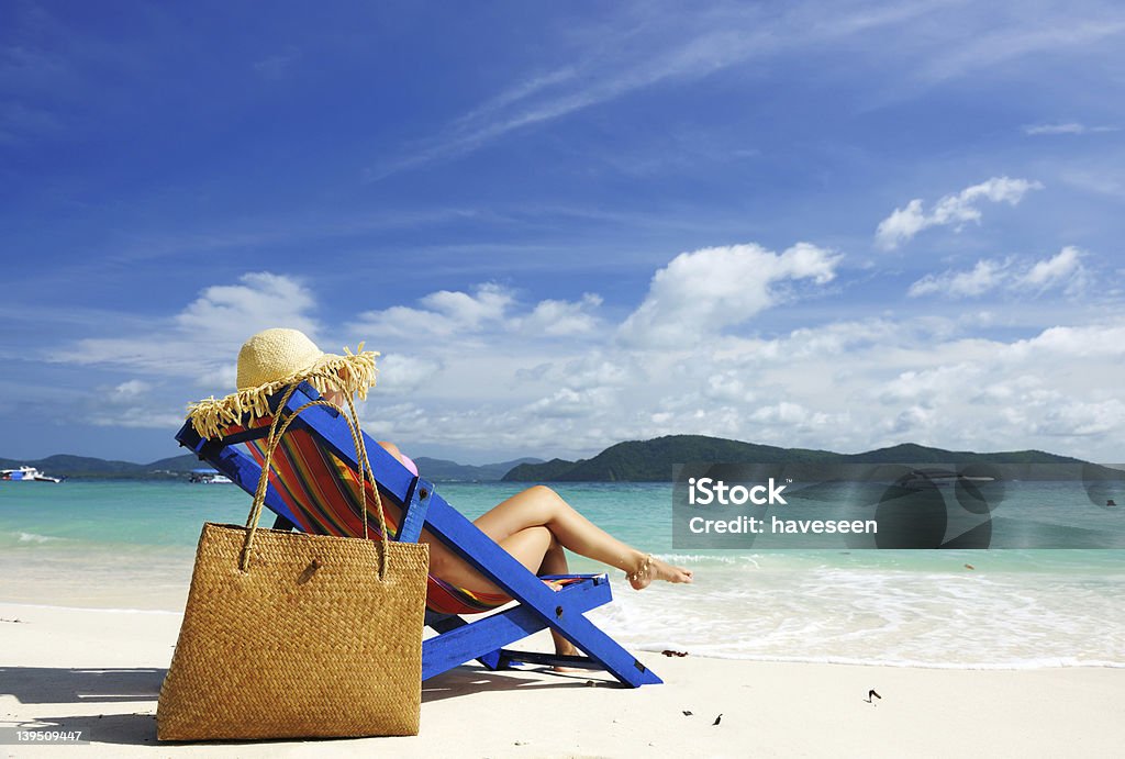 Girl on a beach Girl on a tropical beach in chaise lounge Flip-Flop Stock Photo