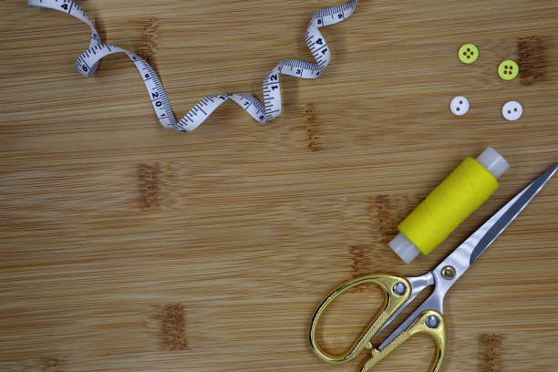 istock Set of sewing accessories on a wooden background. Threads, centimeter and scissors. 1395094975