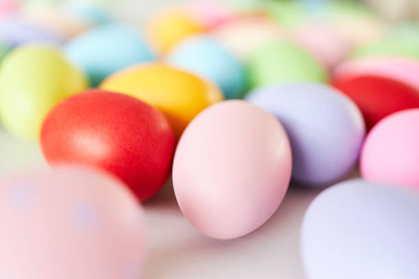 colorful and decorated easter eggs lie on a light gray table photographed with natural light