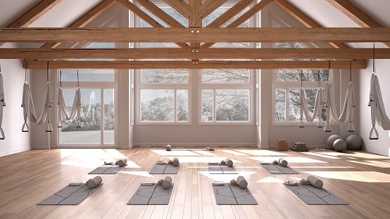 Diseño interior de estudio de yoga vacío, espacio con hamaca, colchonetas, almohadas y accesorios, piso y techo de madera, listo para la práctica de yoga, meditación, ventana panorámica con panorama invernal photo