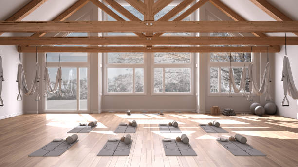 Empty yoga studio interior design, space with hammock, mats, pillows and accessories, wooden floor and roof, ready for yoga practice, meditation, panoramic window with winter panorama stock photo