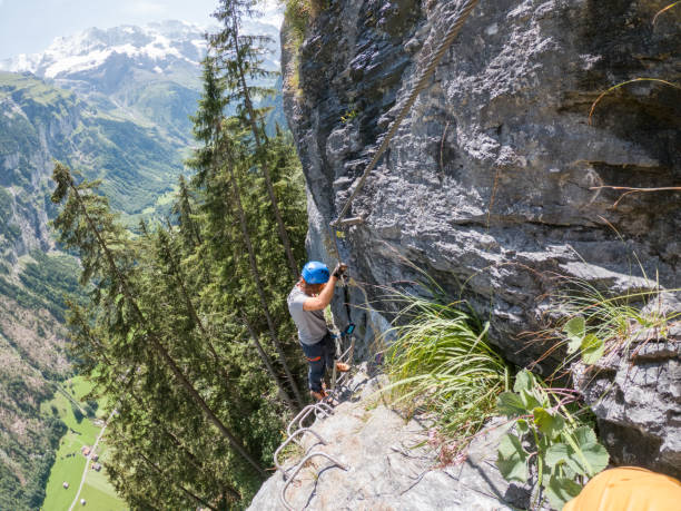 istock Two people on Via Ferrata climbing up, summer activities concept 1395097818