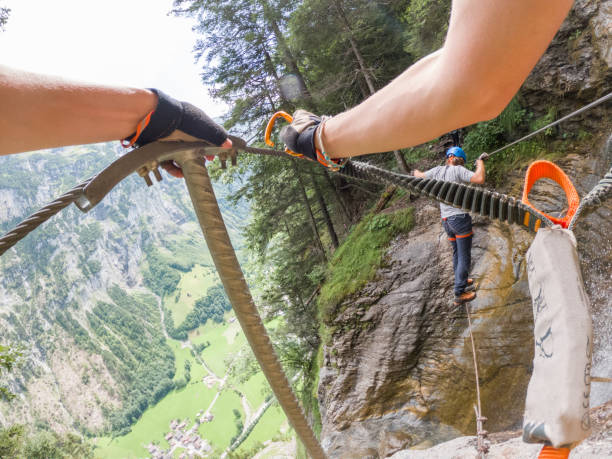 istock Two people on Via Ferrata climbing up, summer activities concept 1395097950