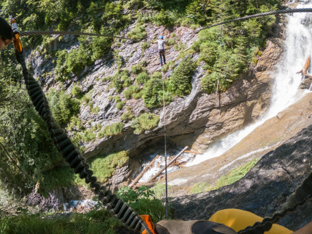 istock Two people on Via Ferrata climbing up, summer activities concept 1395098061
