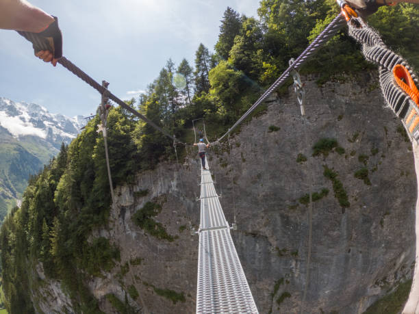 istock Two people on Via Ferrata climbing up, summer activities concept 1395100477