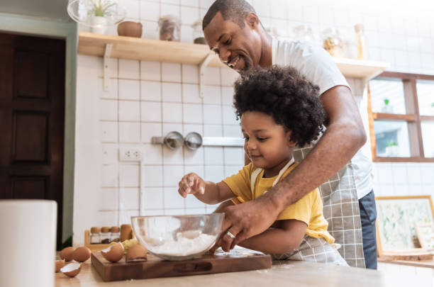 istock Smiling African American Father and little son while cooking in kitchen. 1395101864