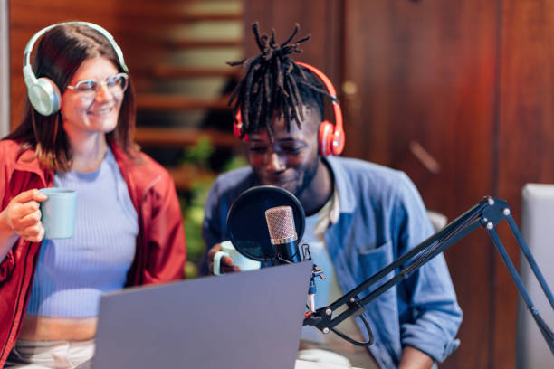 istock detail on microphone in foreground with blurred people in background during live streaming vlogging podcast 1395102658