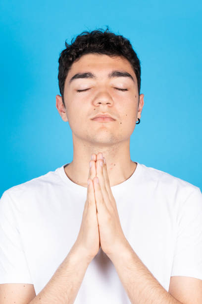istock Believer hispanic teenager boy praying 1395102773