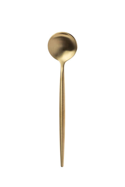 Small round golden spoon isolated on a white background. Top view. Metal teaspoon. stock photo