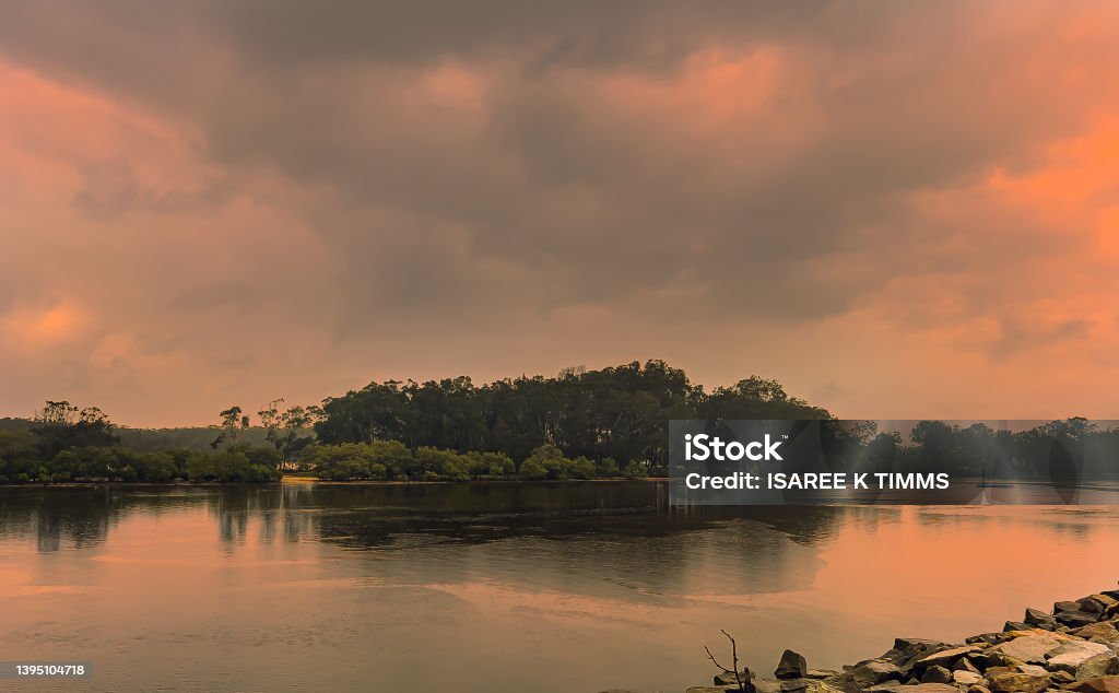 Landscape sunset over river. Landscape spectacular reflections of the golden sunset  in the moody cloudscape  day and  beautiful, calm river  in Coffs Harbour, eastern Australia. Above Stock Photo