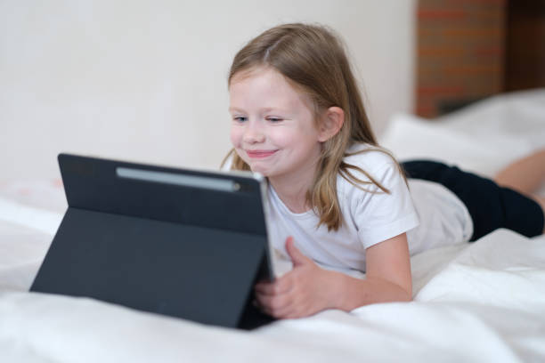 istock Smiling cheerful kid having fun with modern tablet 1395106748