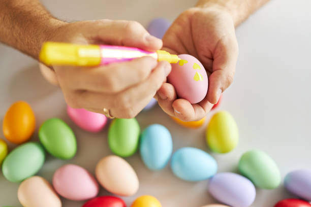 istock An Easter egg decorated and painted by male hands 1395108332