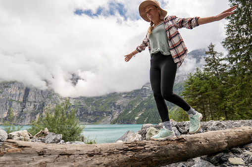 Berner Oberland canton, Switzerland
She walks on a tree trunk along a beautiful blue lake in the center of Switzerland.