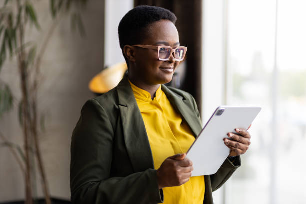 istock Smiling young black businesswoman on tablet 1395110679