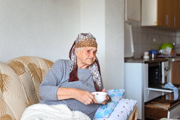 istock Old woman having a meal on the couch 1395113626