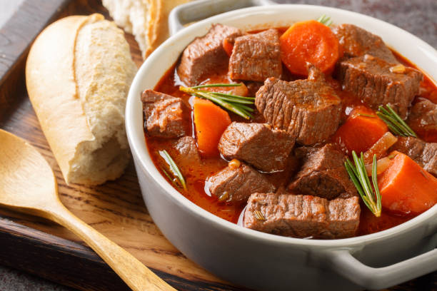 French beef stew in red wine known as daube de boeuf Provencal closeup in the wooden tray. Horizontal French beef stew in red wine known as daube de boeuf Provencal closeup in the wooden tray on the table. Horizontal beef stew stock pictures, royalty-free photos & images