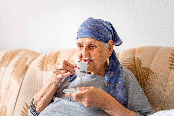 istock Senior woman having a coffee on a sofa 1395113972