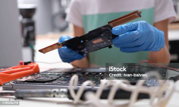 Tech Fixes Motherboard Of Laptop In Service Center Stock Photo - Download Image Now - Computer, Disassembling, Circuit Board