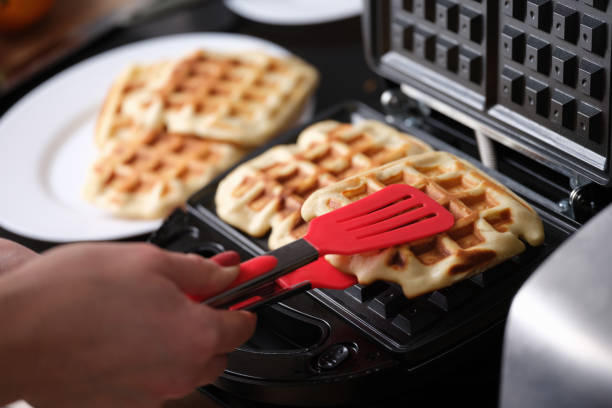istock Waffle iron in kitchen, cooking homemade waffles 1395114736