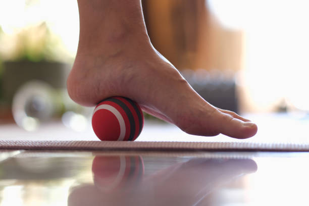 Myofascial release of hyper-movable muscles of foot with massage ball Close-up of myofascial release of hyper-movable muscles of foot with massage ball. Prevention of leg fatigue and foot disease concept pes planus stock pictures, royalty-free photos & images