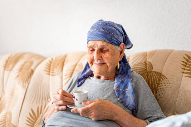 istock Senior woman having a coffee on a sofa 1395114877