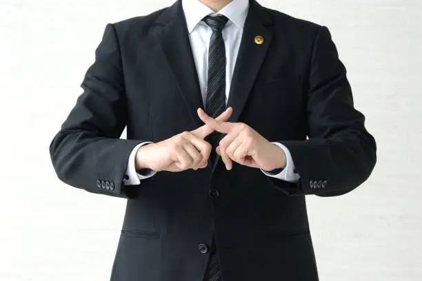 Japanese male lawyer with fingers crossed