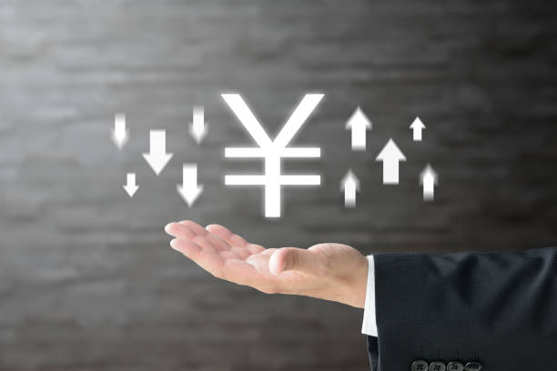 Business man's hand and Japanese yen mark with upward and downward arrows stock photo