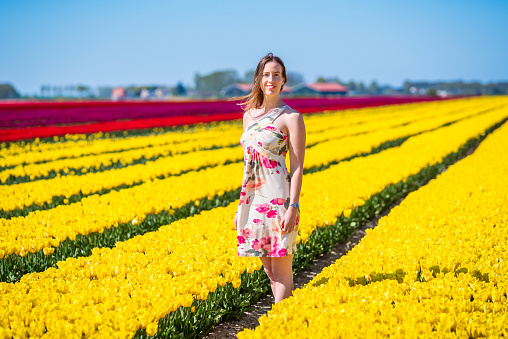 Young woman in yellow tulip fields in Lisse, Netherlands