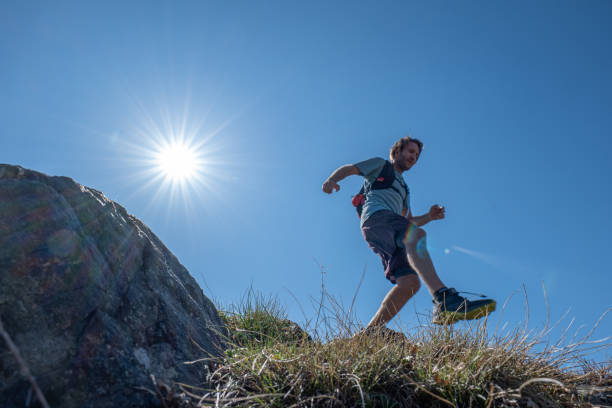 istock Mountain trail runner descends grassy mountain ridge 1395122171