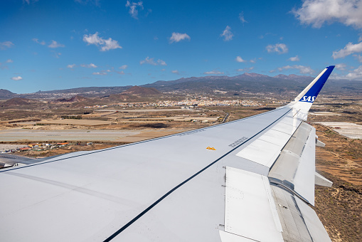 Wing of an Airbus 320NEO airliner from the Scandinavian company SAS during landing on Tenerife South Airport (TFS) on the Spanish Canary island Tenerife