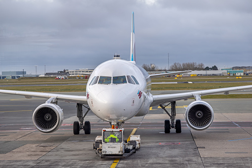 Airbus being pushed away from the gate in Copenhagen Airport at Kastrup on an overcast morning