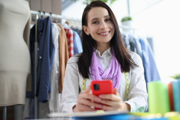 istock Female seamstress smiling and posing in sewing workshop 1395124096