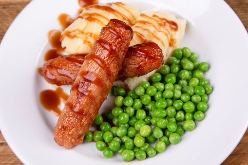 Sausage and mash with peas and gravy.
