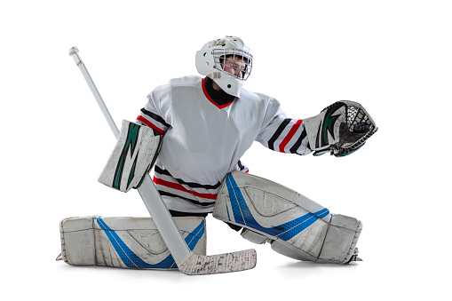 Portrait of teen boy, goalkeeper, hockey player taining isolated over white studio background. Model wearing protective uniform with helmet. Concept of sportive lifestyle, childhood, hobby, action