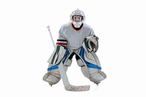 Full-length portrait of boy, hockey player, goalkeeper training, playing isolated over white studio background. Concept of sportive lifestyle, childhood, hobby, action. Copy space for ad