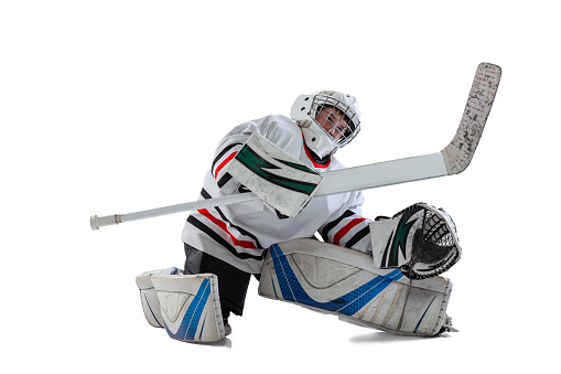 Full-length portrait of young boy, hockey player training, goalkeeper in action isolated over white studio background. Concept of sportive lifestyle, childhood, hobby, action. Copy space for ad
