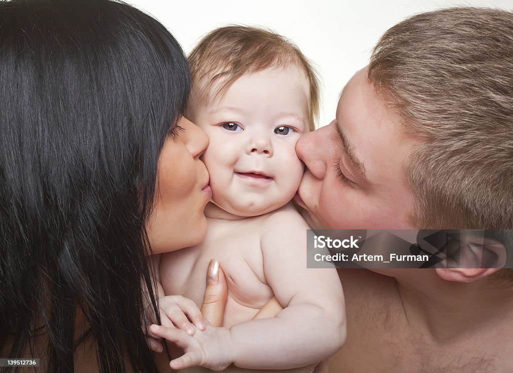 Happy family, mother, father and baby Happy family, mother, father and baby on light background Affectionate Stock Photo