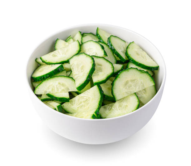 istock Cucumbers cut into pieces in a bowl, isolated on a white background. 1395127483