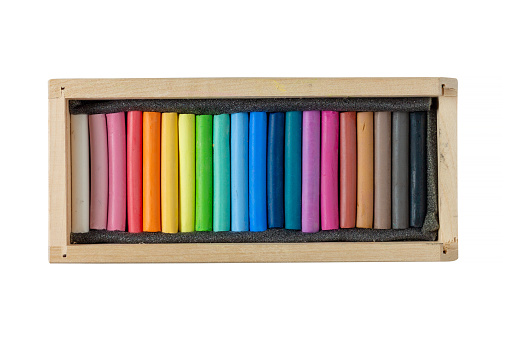 Set of pastel crayons in wooden box isolated on white background