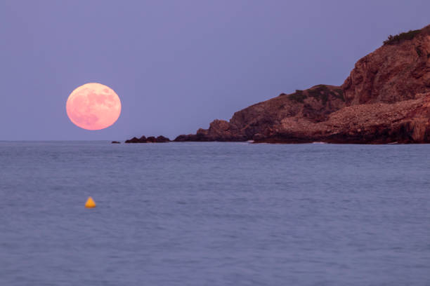 コスタブラバの仲間のビーチから地中海に昇るピンクの月 - super moon ストックフォトと画像