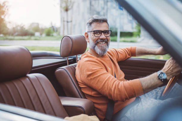 hombre conduciendo coches antiguos por la ciudad - collectors car mature men transportation lifestyles fotografías e imágenes de stock