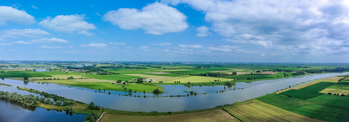 Overflowing floodplains caused by high water level of the river IJssel between Zwolle and Kampen on July 20 2021. Aerial drone point of view over the river and overflown fields after heavy rainfall upstream in Germany.