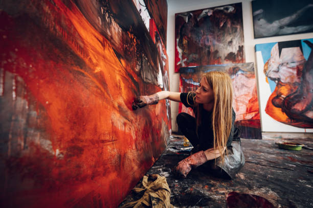 istock Female painter artist painting and creating her art in a creative studio 1395132719